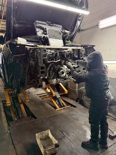 A technician working on the inside of an engine.