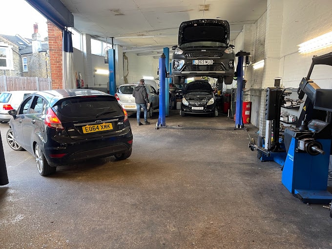 A selection of cars on ramps and parked inside the garage facilities.